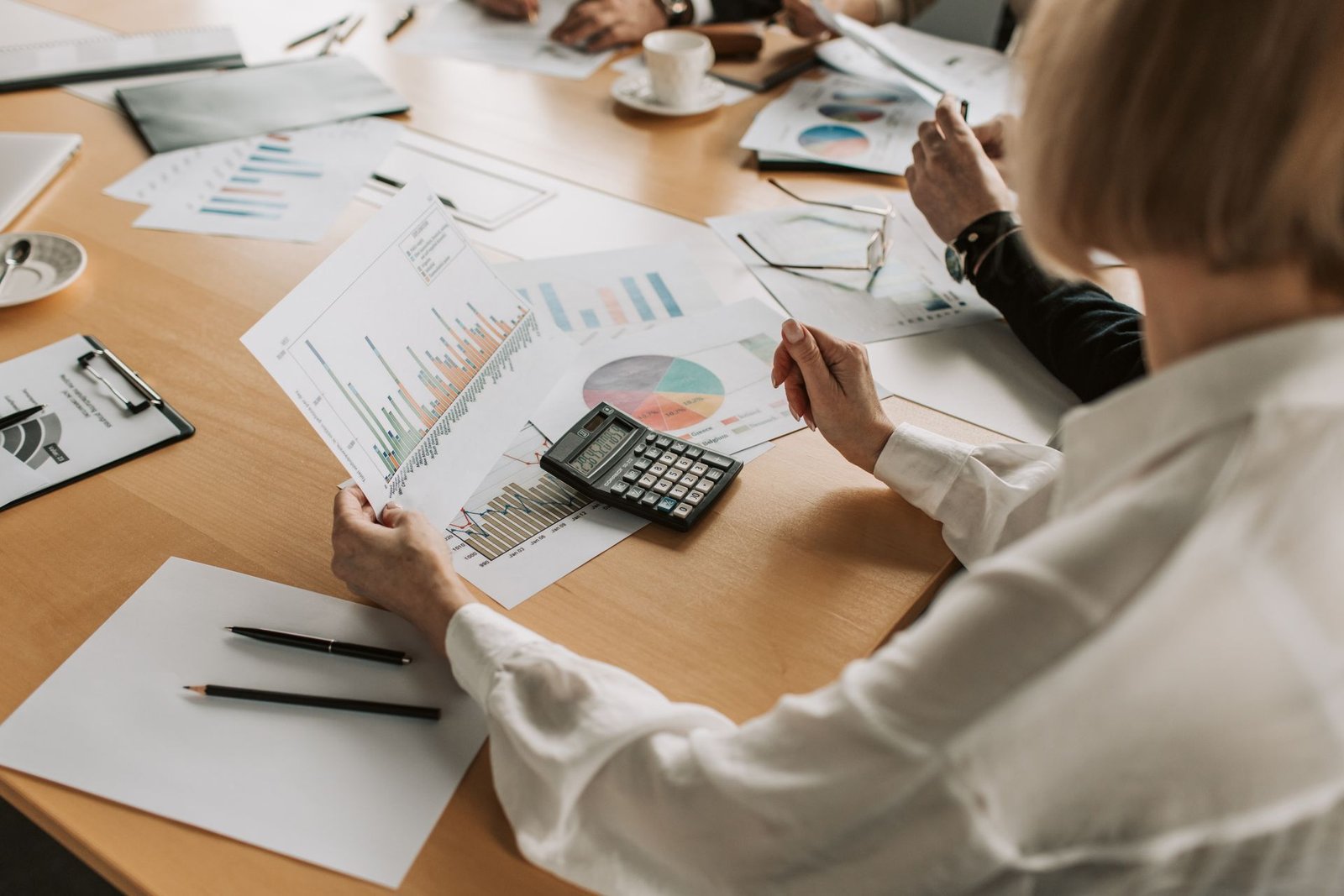 Equipe analisando gráficos e relatórios de resultado sobre a mesa de reunião