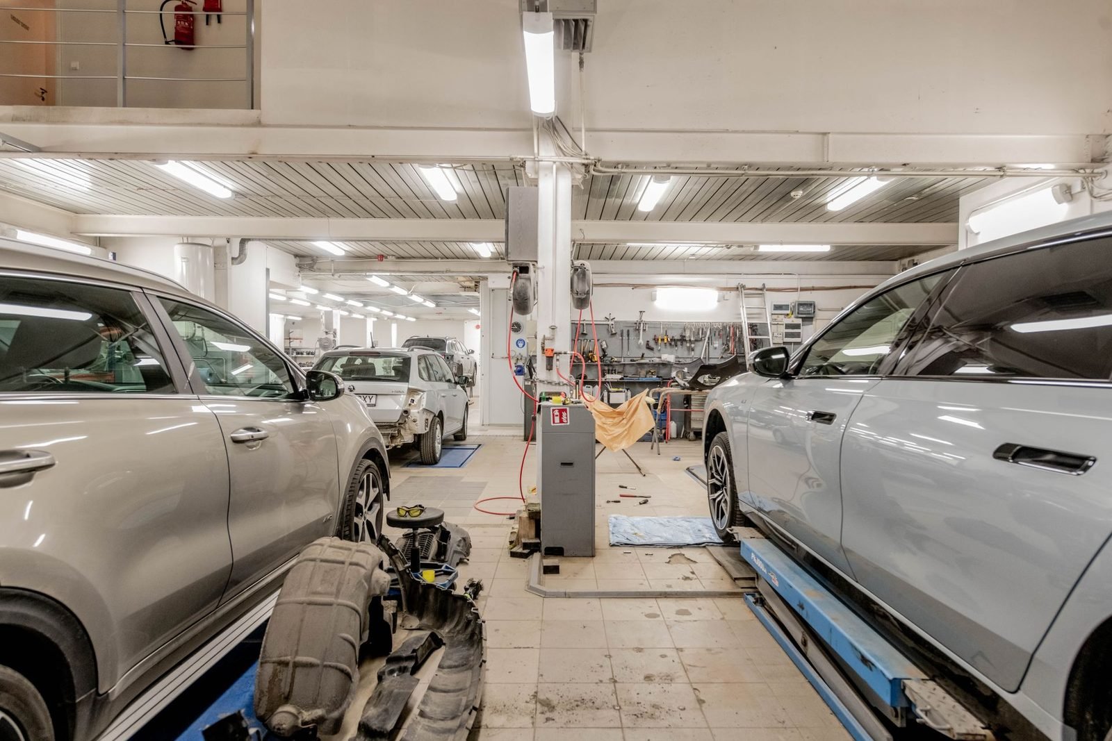 Oficina grande com vários carros enfileirados em manutenção