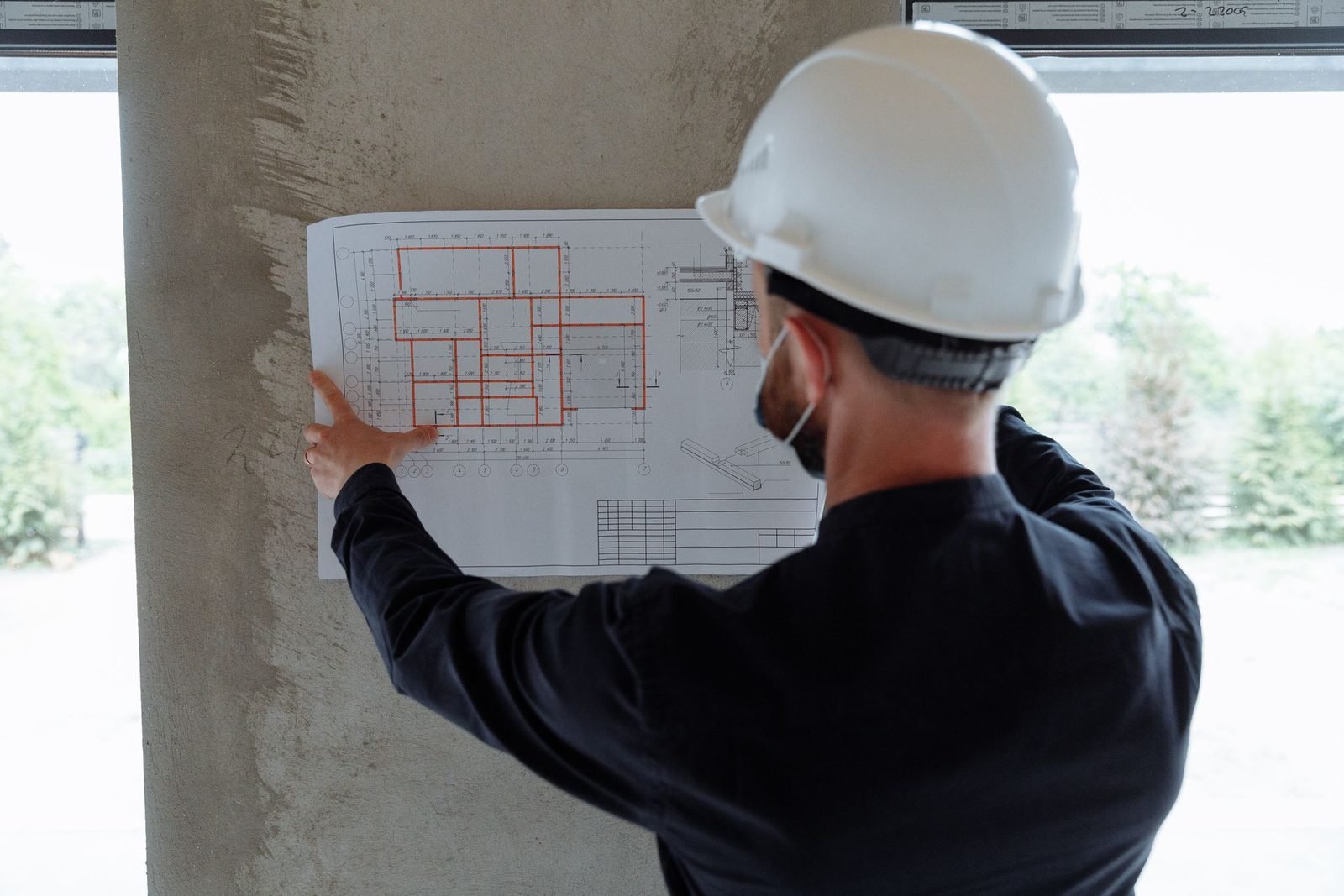 Engenheiro conferindo a planta do projeto no local da obra