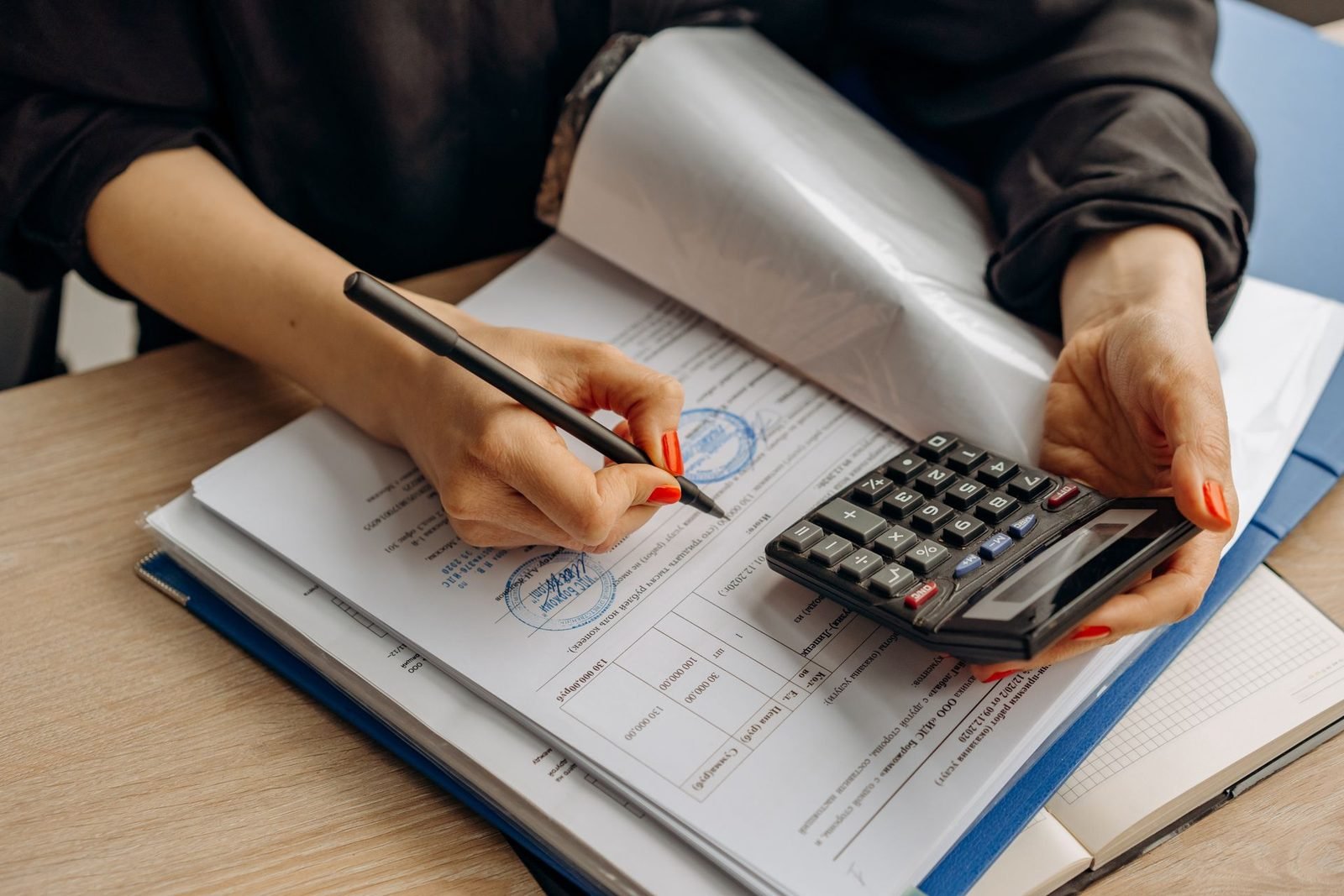 Contador usando a calculadora e assinando documentos no escritório