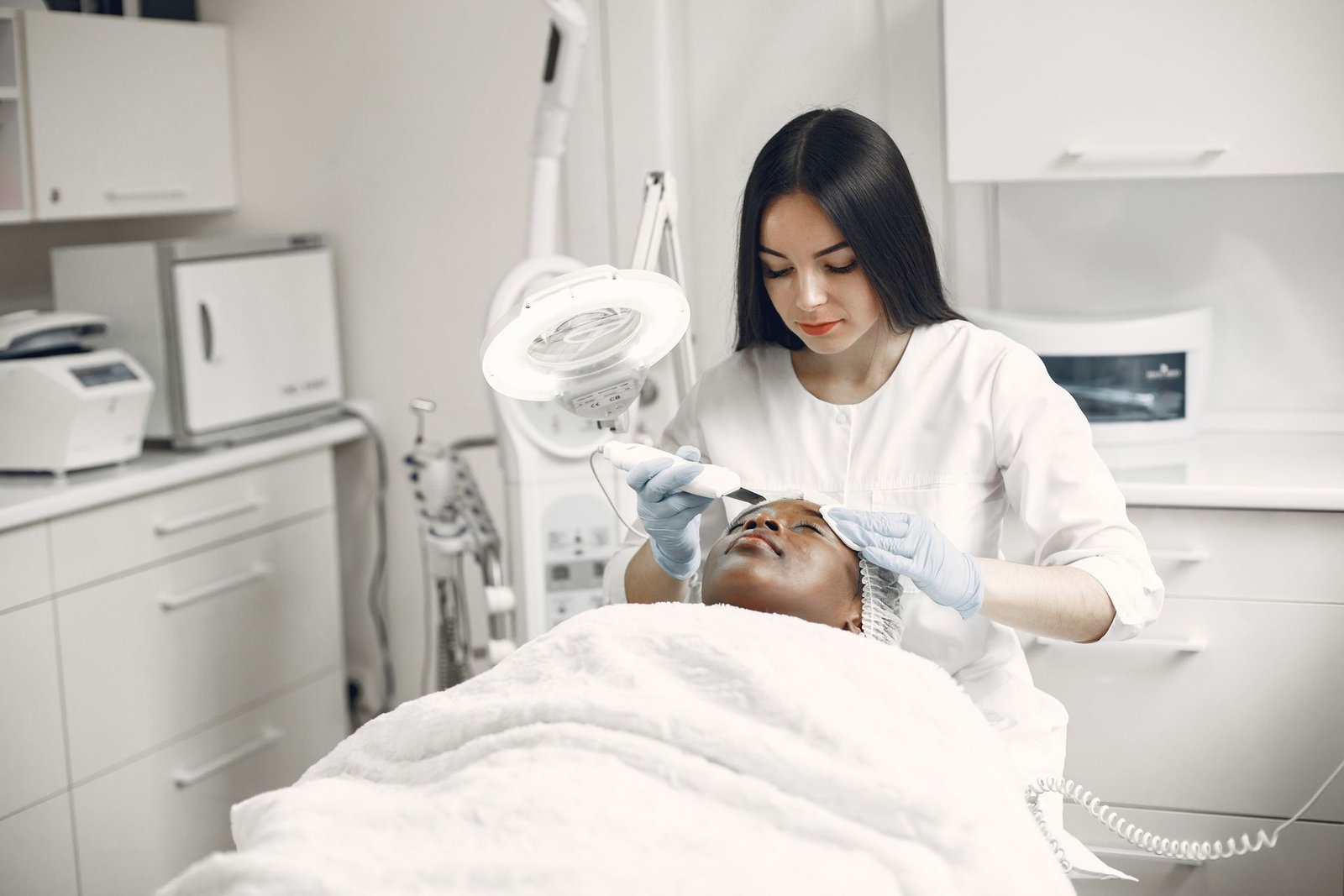 Esteticista de jaleco fazendo um procedimento facial em uma clínica