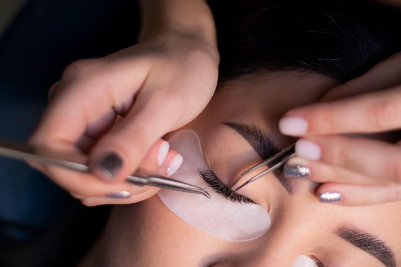 Profissional aplicando extensão de cílios em uma cliente